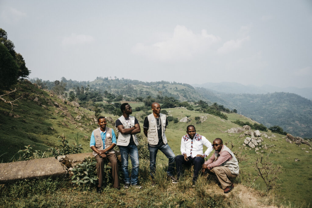 The CRC team in North Kivu, Democratic Republic of Congo. From left to right, Désiré Busimwa, former CRC driver (deceased in 2021); Victor Lety Ezama, formerly responsible of communication, monitoring and learning; Henri Bura Lady, former coordinator of CRC and co-founder of BS-RDC (deceased in 2021); Eddy Byamungu, former coordinator of BS-RDC; Kasongo Blaise, security manager for WHH in Butembo, Nord Kivu. Photo taken by Greg Funnell, 5th July 2016.